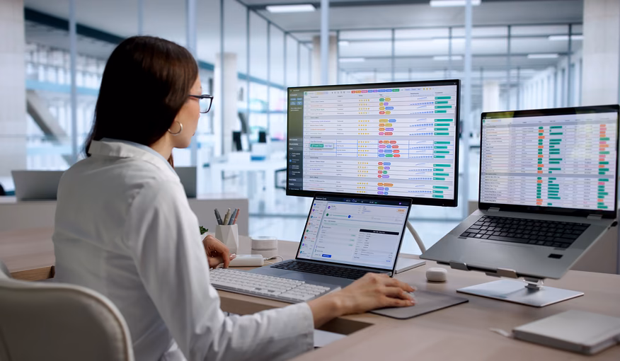 Healthcare operations specialist reviewing digital workflows across multiple screens for revenue cycle automation Healthcare operations specialist reviewing digital workflows across multiple screens for revenue cycle automation