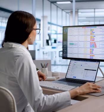 Healthcare operations specialist reviewing digital workflows across multiple screens for revenue cycle automation